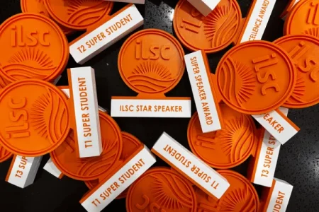 Medalhas personalizadas em impressão 3D para premiação estudantil da escola de inglês ILSC, em detalhe de produção.